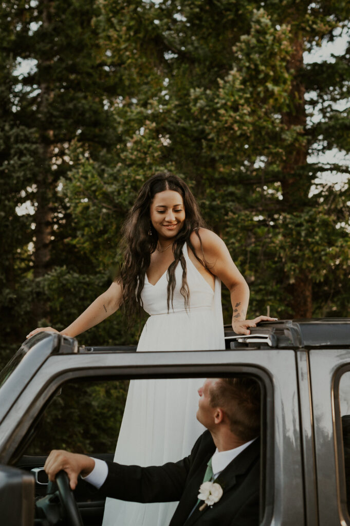 During their Crested Butte elopement, a couple looks at each other in their jeep. 