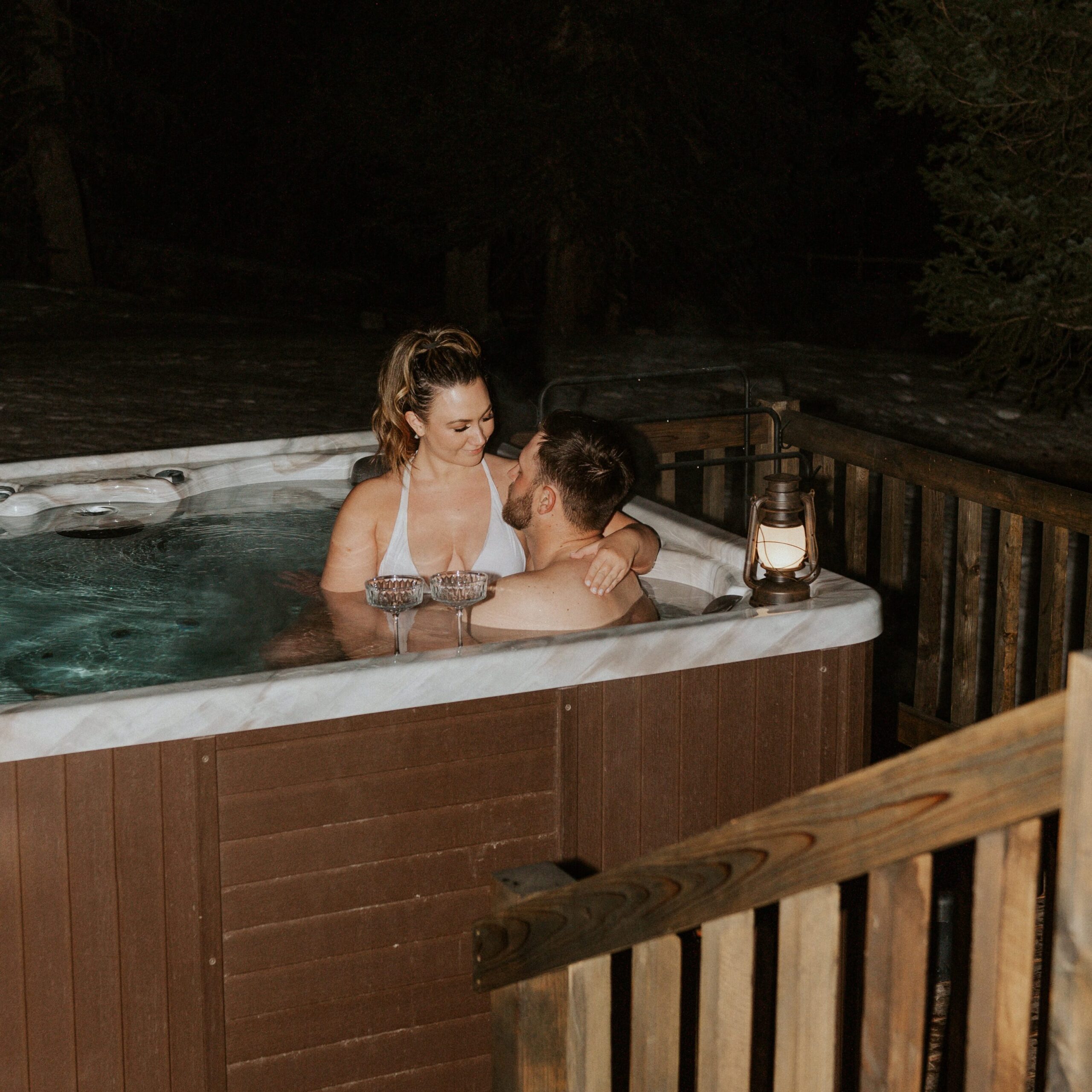 At the end of their winter elopement day, a couple sit in their Airbnb's hot tub, 