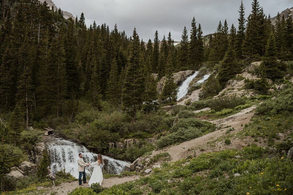 Couple dancing beneath a hidden waterfall in the San Juan Mountains.